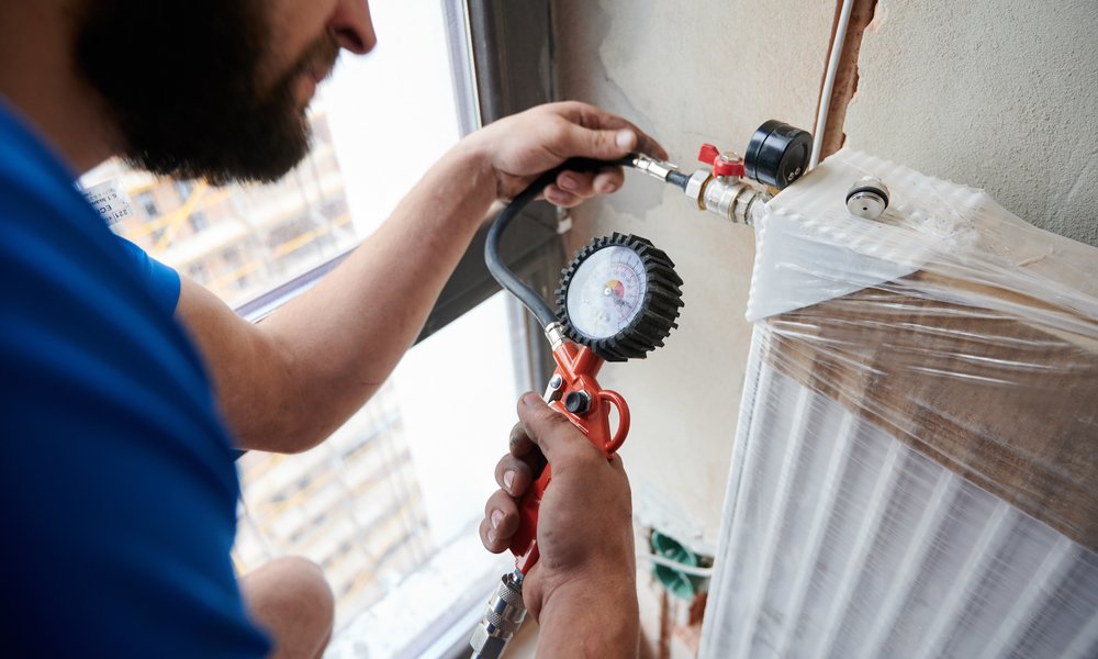 close,up,of,plumber,filling,pipes,with,pressurized,air,to